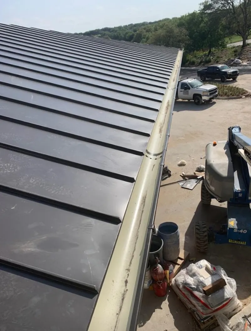 Standing seam panel and gutter detail on a metal roofing jobsite in Champion Heights